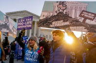Anti-abortion protesters wear shirts that read "I am the Pro-Life Generation" and hold signs as they demonstrate in front of the U.S. Supreme Court, Wednesday, Dec. 1, 2021, in Washington, as the court hears arguments in a case from Mississippi, where a 2018 law would ban abortions after 15 weeks of pregnancy, well before viability. (AP Photo/Andrew Harnik)