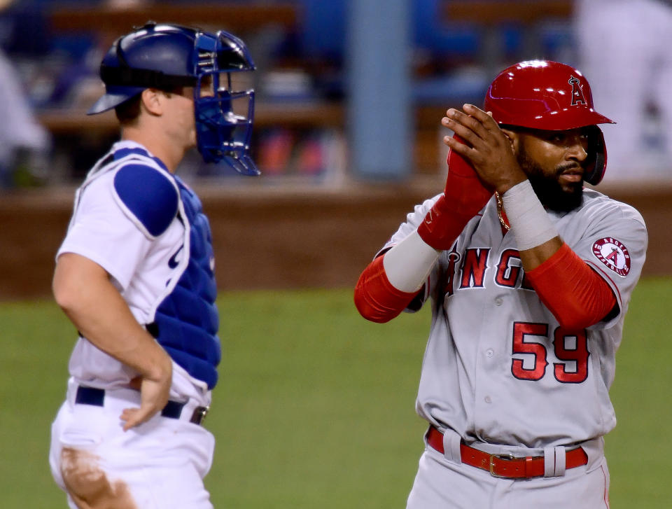 Jo Adell #59 of the Los Angeles Angels celebrates his run in front of Will Smith #16 of the Los Angeles Dodgers.