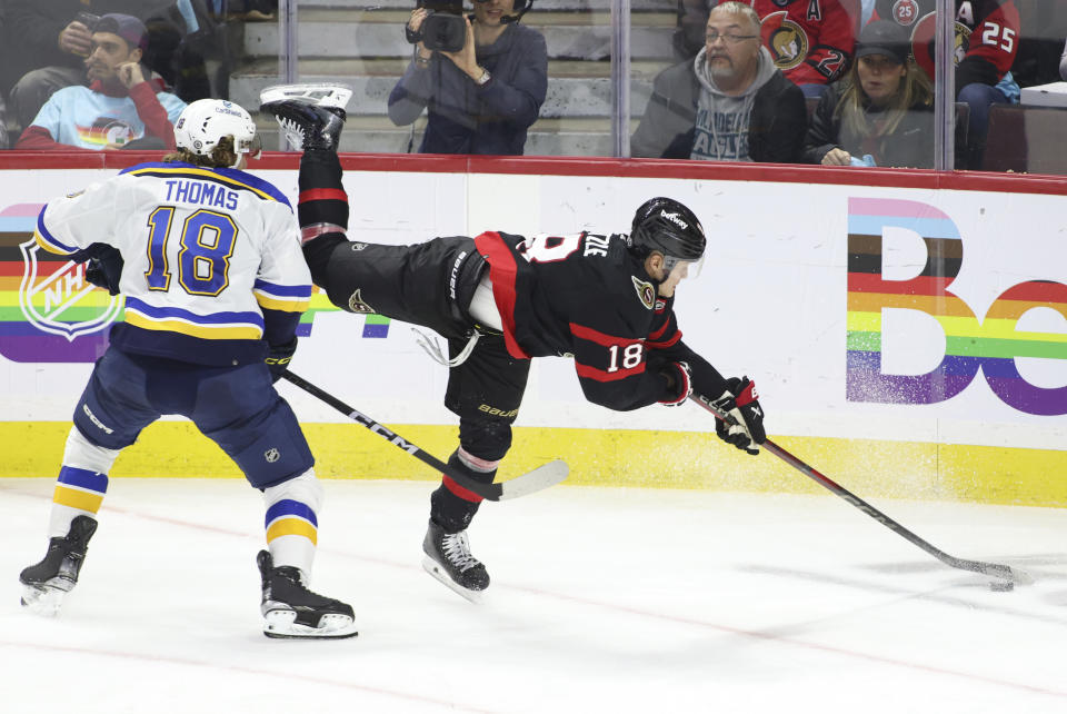 Ottawa Senators' Tim Stutzle, right, reaches for the puck in front of St. Louis Blues' Robert Thomas during the third period of an NHL hockey game in Ottawa, Ontario, on Thursday, March 21, 2024. (Patrick Doyle/The Canadian Press via AP)