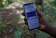 Cyril Fianyo, a farmer and beneficiary under the Uniti Networks project, shows a message he received on his phone at his farm in Atabu, Hohoe, in Ghana's Volta region, Wednesday, April 18, 2024. Internet-enabled phones have transformed many lives, but they can play a unique role in sub-Saharan Africa, where infrastructure and public services are among the world's least developed. (AP Photo/Misper Apawu)