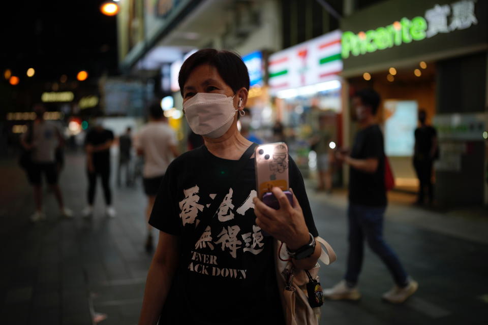 Pro-democracy protester holds an illuminated cell phone near Hong Kong's Victoria Park, Saturday, June 4, 2022. Dozens of police patrolled Hong Kong’s Victoria Park on Saturday after authorities for a third consecutive year banned public commemoration of the anniversary of the deadly Tiananmen Square crackdown in 1989, with vigils overseas the only place marking the event. (AP Photo/Kin Cheung)