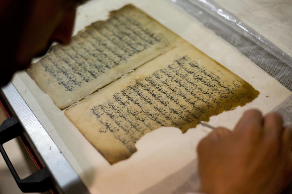 In this photo taken on Monday, Jan. 27, 2014, an employee works on a restoration of an old manuscript at the al-Aqsa mosque compound library in Jerusalem. The library has a collection of some 4,000 old manuscripts with about a quarter considered in poor condition. Half of the books are already undergoing restoration funded by the Waqf, Jordan’s Islamic authority which manages the holy site, and with assistance from UNESCO. (AP Photo/Dusan Vranic)