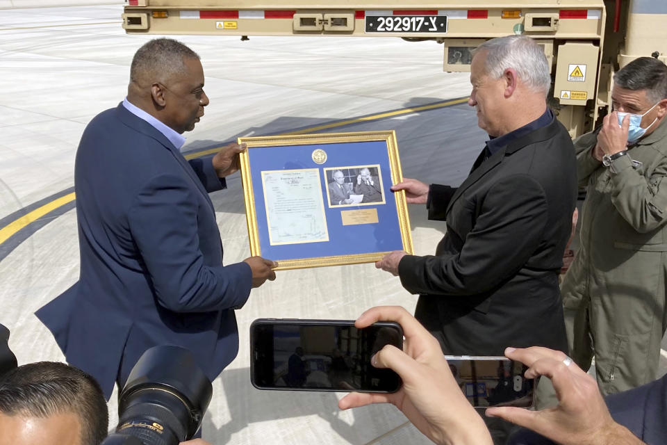 U.S. Defense Secretary Lloyd Austin, left, presents Israeli Defense Minister Benny Gantz, right, with a framed copy of a formerly Top Secret memo regarding U.S. consideration of granting official recognition of the state of Israel shortly after its creation in 1948, at Nevatim Israeli Air Force Base, Monday, April 12, 2021 in Israel. The inset photo on right shows President Truman and Secretary of State George Marshall. (AP Photo/Robert Burns)