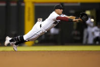 Arizona Diamondbacks' Josh Rojas can't stop a base hit by Cincinnati Reds' Nick Castellanos during the fifth inning of a baseball game, Friday, April 9, 2021, in Phoenix. (AP Photo/Matt York)