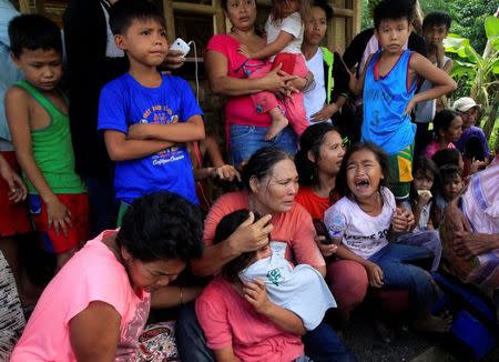 Residents who want to evacuate from their homes gather while waiting for a vehicle after Islamist militants, who had holed up in a primary school, retreated after a gunbattle with troops but were holding some civilians hostage, in Pigcawayan, North Cotabato, Philippines June 21, 2017. REUTERS/Marconi Navales