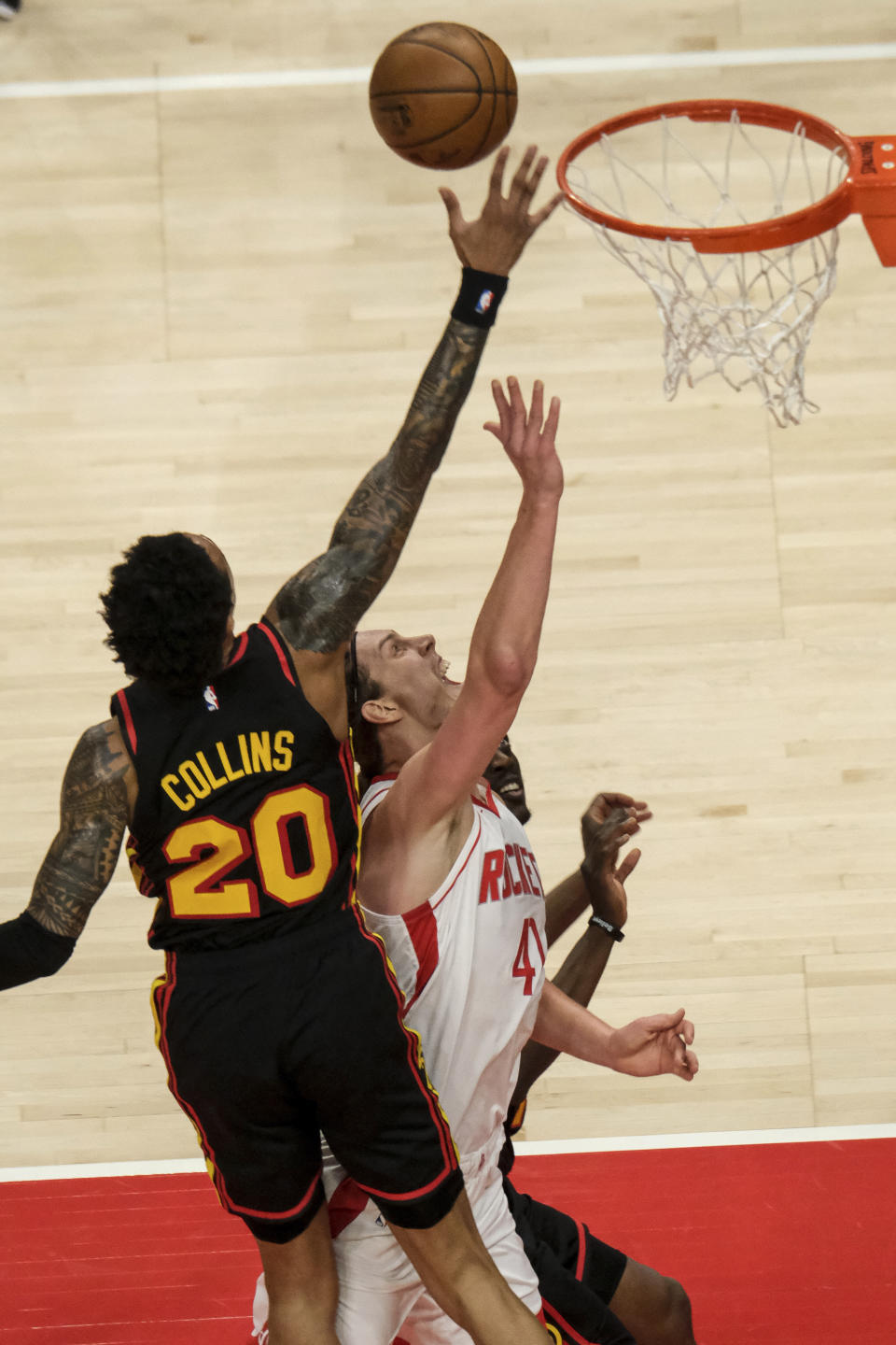 Atlanta Hawks forward John Collins (20) blocks a shot by Houston Rockets forward Kelly Olynyk (41) during the first half of an NBA basketball game on Sunday, May 16, 2021, in Atlanta. (AP Photo/Ben Gray)