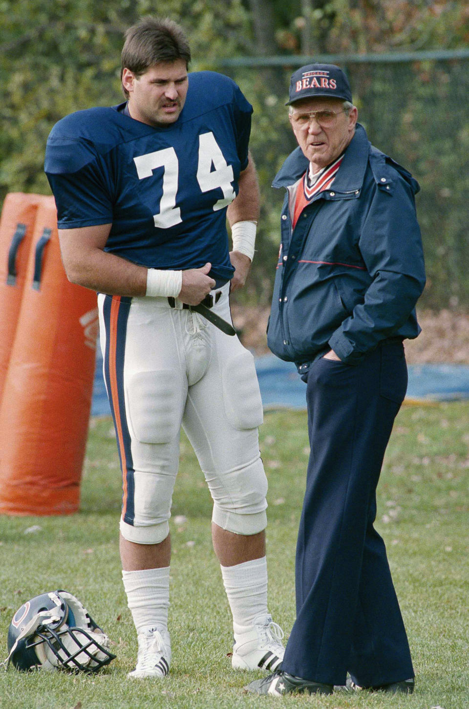 FILE - In this Nov. 2, 1988, file photo, Chicago Bears offensive coordinator Ed Hughes, right, speaks with Jim Covert during NFL football practice in Lake Forest, Ill. Covert made the people he played alongside look good, and after a nearly two-decades-long wait, the tough Chicago Bears left tackle will join them in the Pro Football Hall of Fame. (AP Photo/Mark Elias, File)