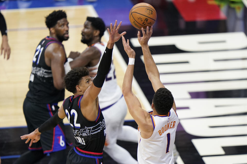 Phoenix Suns' Devin Booker, right, goes up for a shot against Philadelphia 76ers' Matisse Thybulle during the second half of an NBA basketball game, Wednesday, April 21, 2021, in Philadelphia. (AP Photo/Matt Slocum)