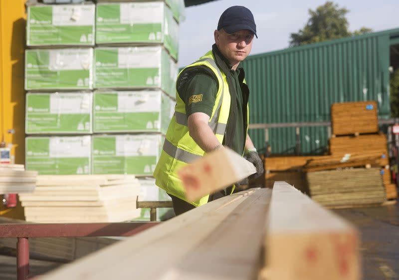 A worker stacks timber at the Vauxhall depot of building material supplier Travis Perkins in London, Britain October 25, 2013. REUTERS/Neil Hall/File Photo