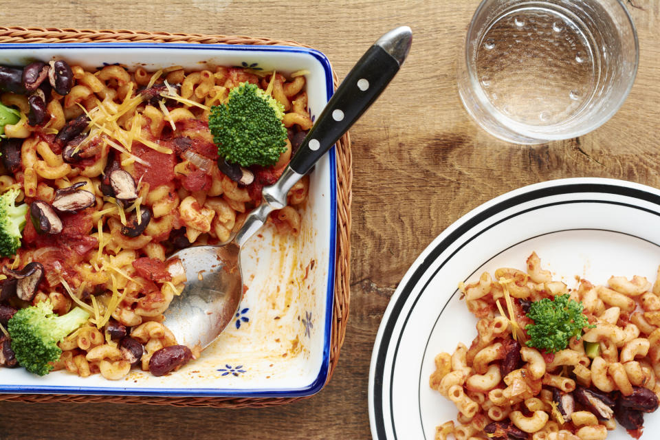 A casserole on a table with plates next to it