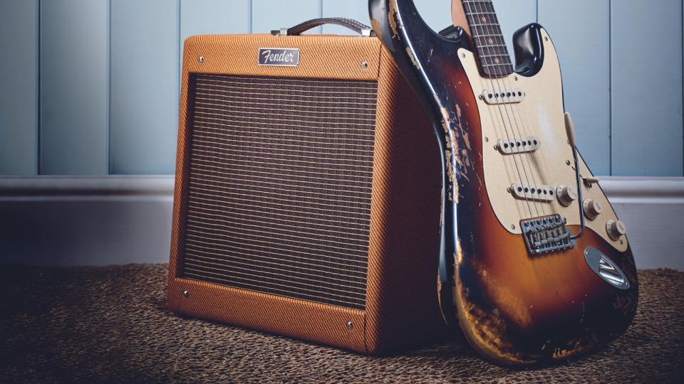 A Fender Pro Junior guitar amp with a vintage Fender Stratocaster