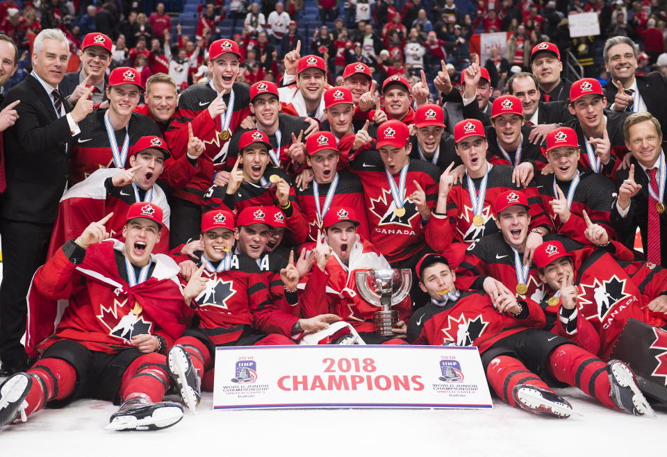 FILE - The Canadian team poses for a photo after winning the gold medal with a 3-1 win over Sweden during the third period the title game of the IIHF world junior hockey championships, Friday, Jan. 5, 2018, in Buffalo, N.Y. Five players from Canada's 2018 world junior team have taken a leave of absence from their respective clubs in recent days amid a report that five members of that team have been asked to surrender to police to face sexual assault charges. New Jersey’s Michael McLeod and Cal Foote, Philadelphia’s Carter Hart, Calgary’s Dillon Dube and former NHL player Alex Formenton have all been granted indefinite leave, with the absences announced this week. (Nathan Denette/The Canadian Press via AP, File)