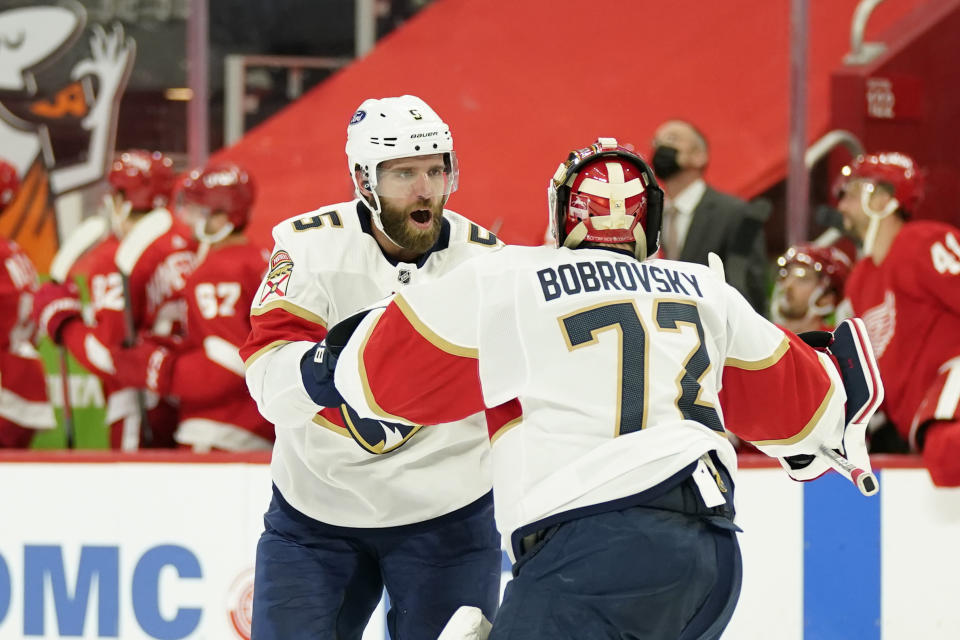 Florida Panthers defenseman Aaron Ekblad (5) congratulates goaltender Sergei Bobrovsky (72) after their overtime win over the Detroit Red Wings in an NHL hockey game, Saturday, Jan. 30, 2021, in Detroit. (AP Photo/Carlos Osorio)