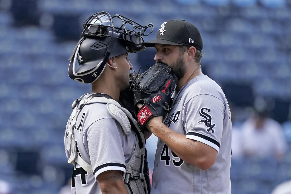 Chicago White Sox relief pitcher Kendall Graveman and catcher Seby Zavala meet on the mound during the seventh inning of a baseball game against the Kansas City Royals Monday, Aug. 22, 2022, in Kansas City, Mo. (AP Photo/Charlie Riedel)