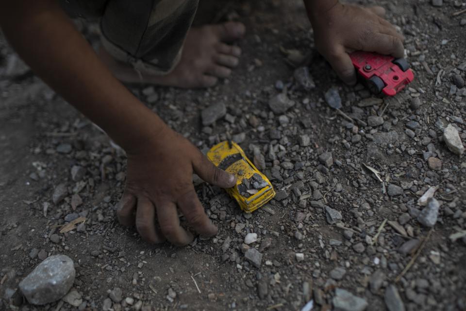 FILE - In this Thursday, Oct. 3, 2019 file photo a Syrian boy plays with a toy car at the Moria refugee and migrant camp on the Greek island of Lesbos. An international human rights organization says on Wednesday, Dec. 18, 2019, hundreds of unaccompanied children in a migrant camp on the eastern Aegean island of Lesbos are living in "inhuman and degrading" conditions that threaten their mental and physical wellbeing. (AP Photo/Petros Giannakouris, File)