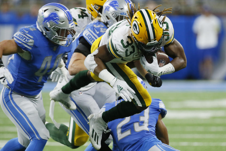Green Bay Packers running back Aaron Jones (33) is tackled by Detroit Lions linebacker Alex Anzalone (34) during the first half of an NFL football game, Sunday, Nov. 6, 2022, in Detroit. (AP Photo/Duane Burleson)
