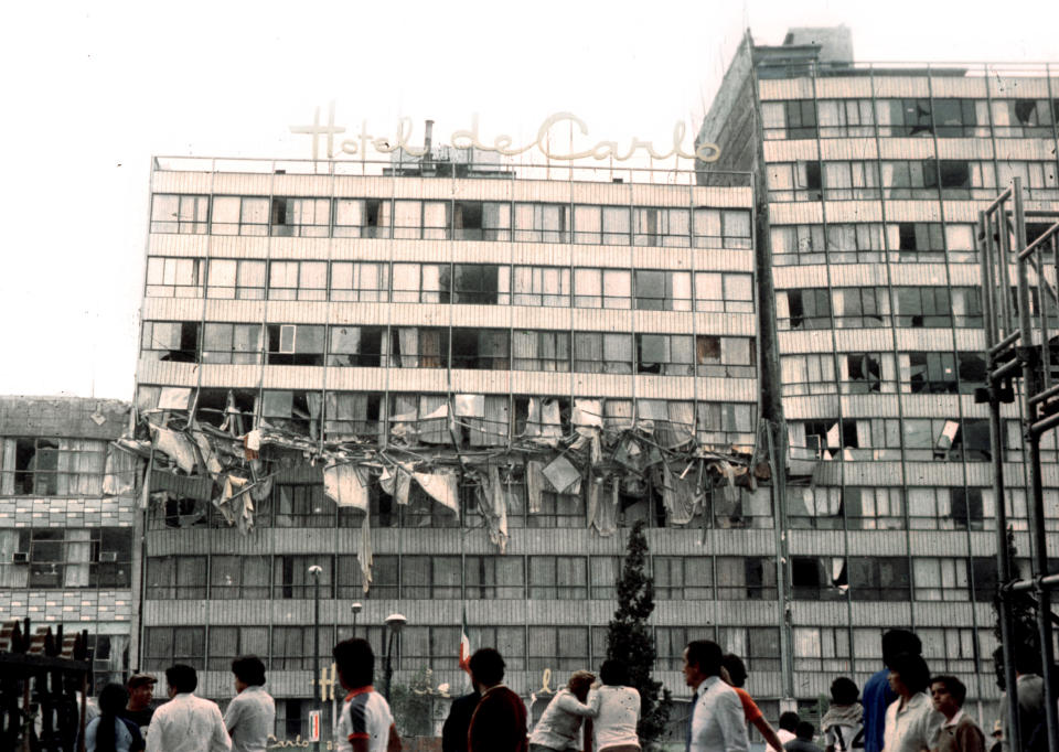 People look at the damaged Hotel De Carlo in Revolution Plaza in Mexico City after an earthquake in this September 19, 1985 file photo. The 1985 Mexico City earthquake, measuring a giddy 8.1 on the Richter scale, caught Mexico off guard, killing thousands as it toppled housing blocks and office buildings in a city built on the soft mud left by a dried-up pre-Hispanic lake.Some 12,000 people are believed to have died in this earthquake, with another 40,000 injured. President Vicente Fox will host a memorial service on September 19, 2005 for the victims as the country marks the quake's 20th anniversary. REUTERS/Daniel Aguilar/File  DA/VP