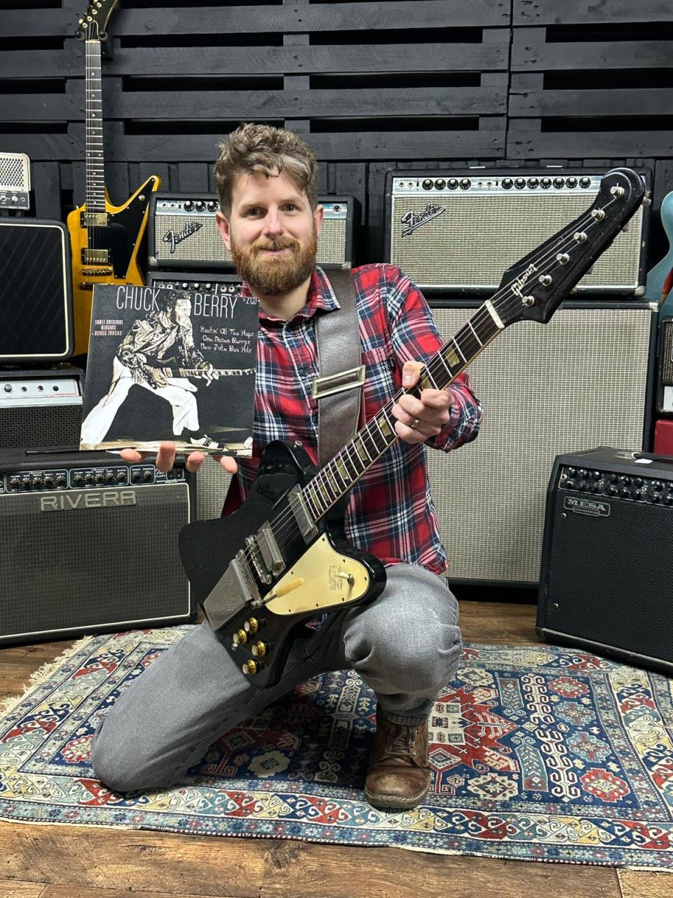 Auctioneer Luke Hobbs posing with Chuck Berry's guitar (Gardiner Houlgate/PA)