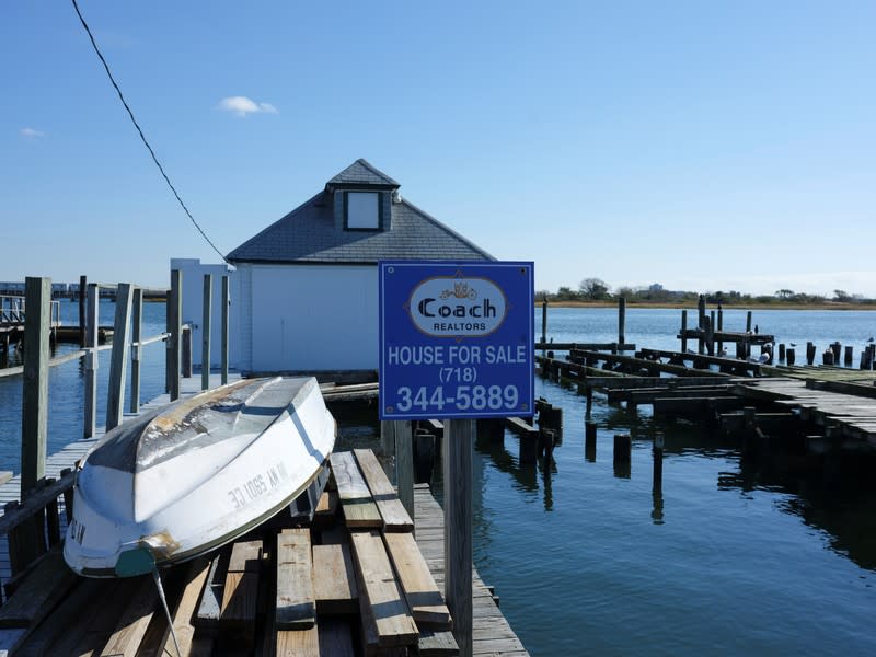 Un cartel de "a la venta" anunciando una casa disponible junto a los postes derrumbados de una casa destruida por el huracán Sandy, en el vecindario Broad Channel de Queens, en la ciudad de Nueva York, EEUU, el 2 de noviembre de 2019