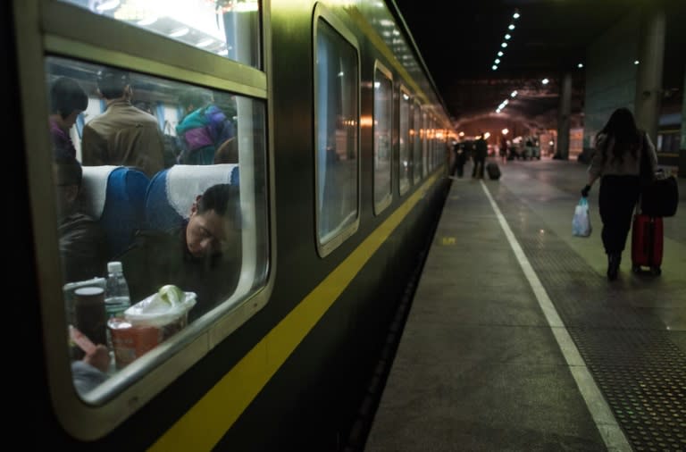 A passenger sleeps on a train as he heads to his hometown for the Lunar New Year holiday at Shanghai South railway station in Shanghai on February 4, 2016