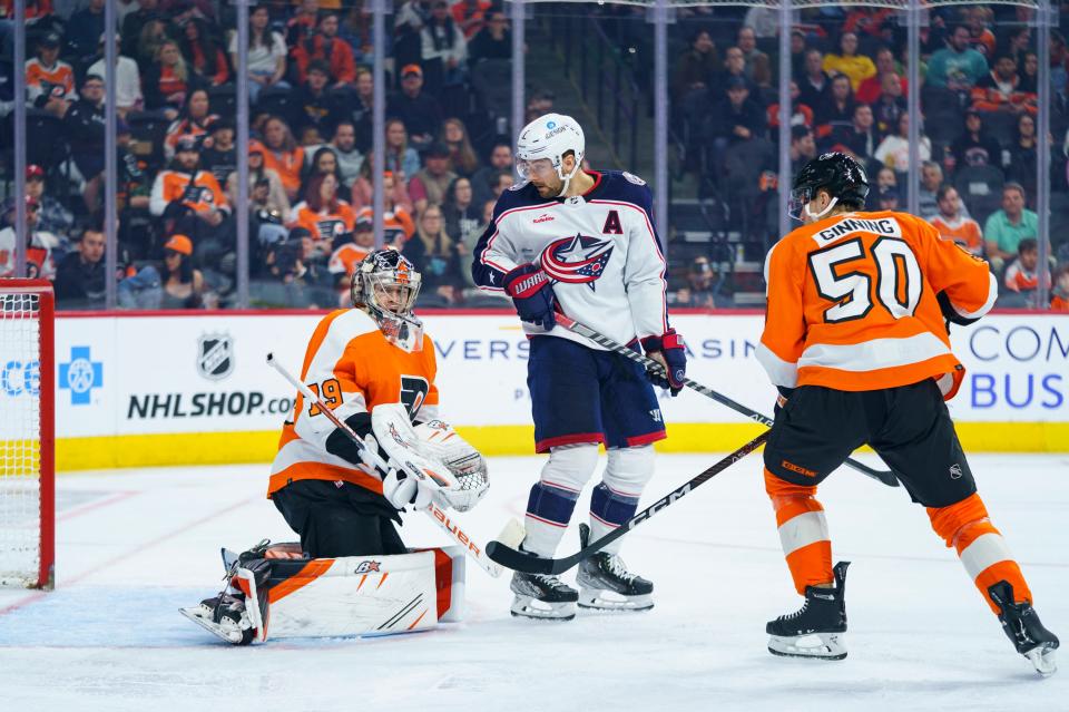 Columbus Blue Jackets' Sean Kuraly, center, looks back as he scores a goal against Philadelphia Flyers' Carter Hart, left, during the third period an NHL hockey game Tuesday, April 11, 2023, in Philadelphia. The Flyers won 4-3 in overtime. (AP Photo/Chris Szagola)