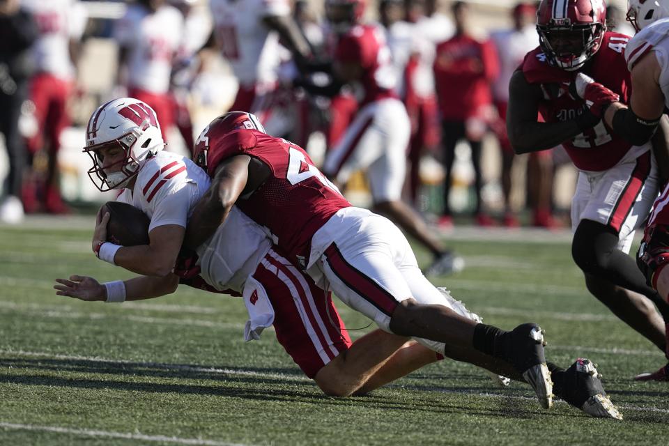 Wisconsin quarterback Braedyn Locke (18) is sacked by Indiana linebacker Aaron Casey (44) during the second half of an NCAA college football game, Saturday, Nov. 4, 2023, in Bloomington, Ind. (AP Photo/Darron Cummings)