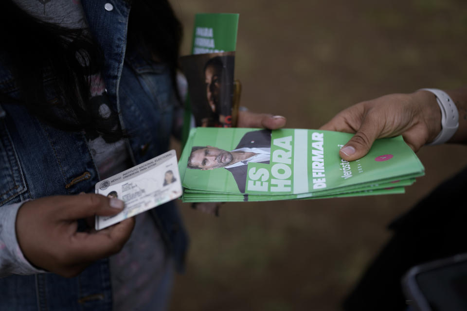 A volunteer hands out campaign brochures promoting presidential hopeful Eduardo Verastegui during a rally to collect signatures to enable him to run as an independent candidate in the 2024 presidential election, in San Bartolo del Valle, Mexico, Friday, Nov. 10, 2023. Rallying all over the country to fulfill the task of gathering 1 million signatures by early January, the 49-year-old right-wing activist has ignited controversy in this deeply Catholic nation, where abortion activists and the LGBTQ+ community lead advocacy campaigns of their own.(AP Photo/Eduardo Verdugo)