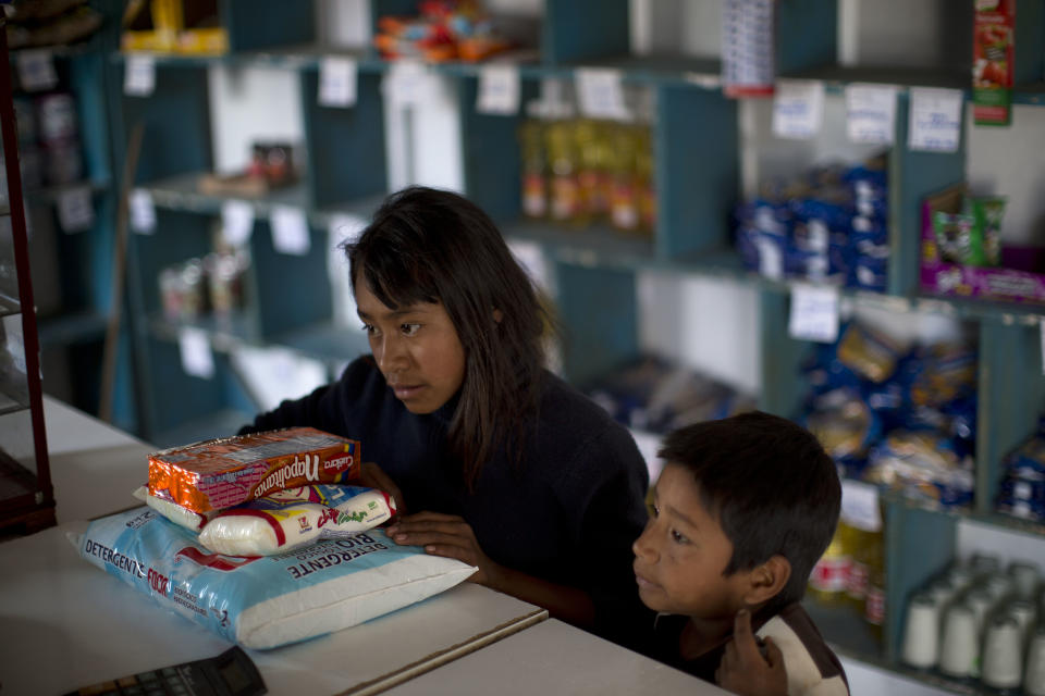 In this Feb. 11, 2014 photo, children buy a bag of sugar, cookies and detergent at a state-run store in Cochoapa El Grande, Mexico. Much of the food is canned or packaged and shipped from major cities, a practice experts and indigenous advocates called a missed opportunity to help the development of local agriculture. (AP Photo/Dario Lopez-Mills)