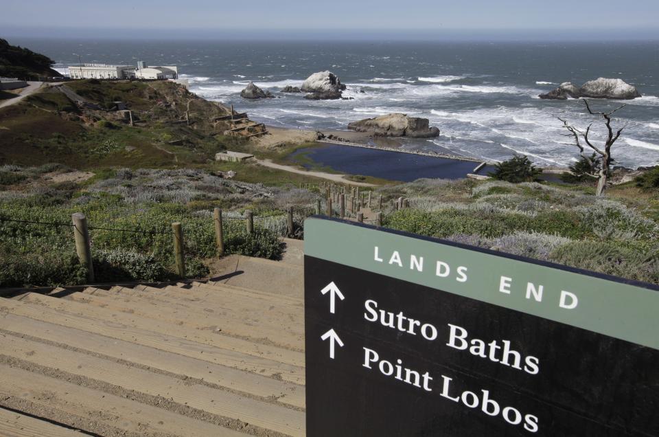 In this photo taken Thursday, May 24, 2012, a sign lead down the path to the ruins of the Sutro Baths at Lands End in San Francisco. At left is the Cliff House. (AP Photo/Eric Risberg)