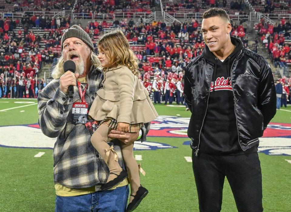 Former Fresno State baseball coach Mike Batesole addresses the crowd while Aaron Judge stands by during a jersey retirement celebration at halftime of the Bulldogs’ game against New Mexico at Valley Children’s Stadium on Saturday, Nov. 18, 2023.