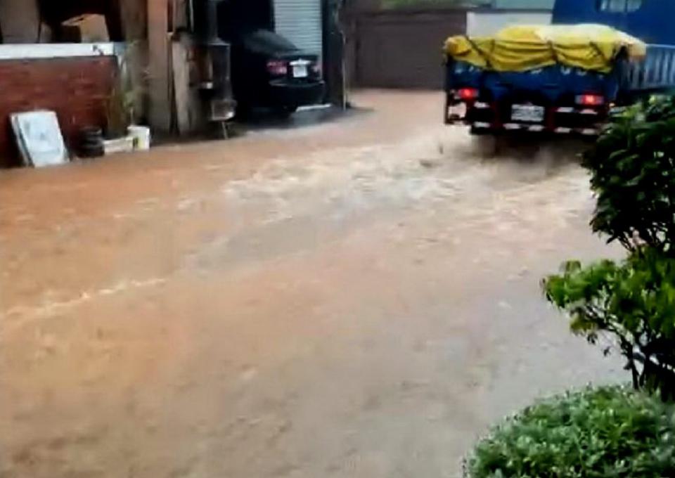 台中市昨日下午下起滂沱大雨，清水區東山里神清路段也嚴重積水，車輛經過淹激起嚴重水花。（記者陳金龍攝）