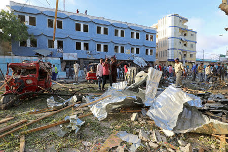 Somali security forces and civilians assess the damage at the scene of an explosion outside Weheliye Hotel in Maka al Mukarama street in Mogadishu, Somalia March 22, 2018. REUTERS/Feisal Omar