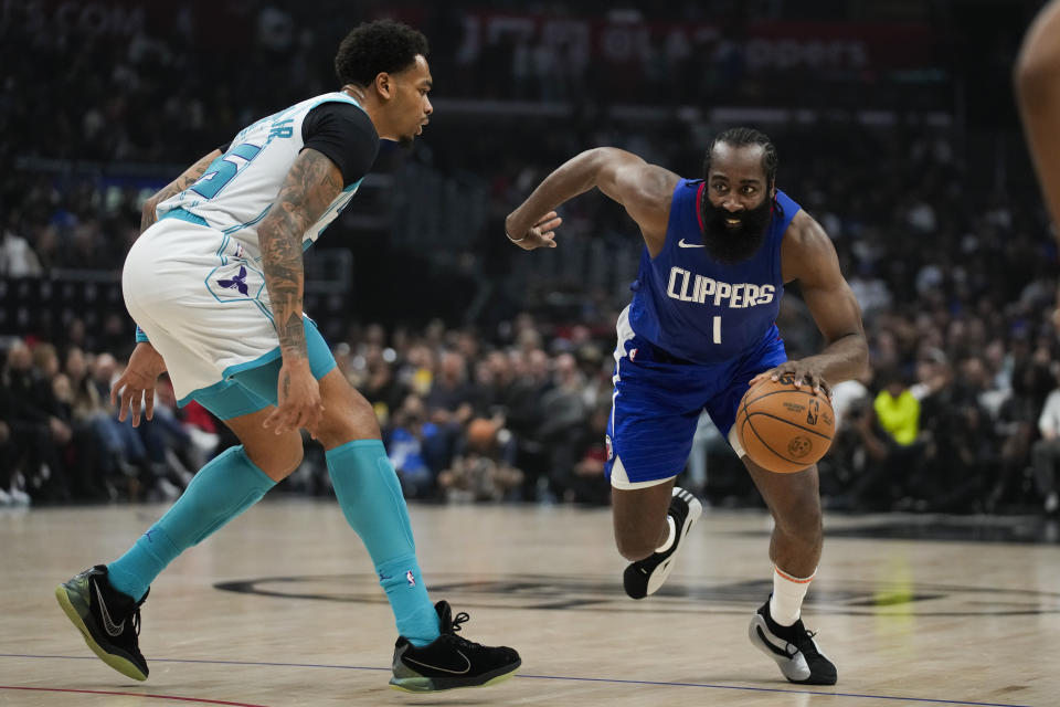 Charlotte Hornets forward P.J. Washington (25) defends against Los Angeles Clippers guard James Harden (1) during the first half of an NBA basketball game in Los Angeles, Tuesday, Dec. 26, 2023. (AP Photo/Ashley Landis)