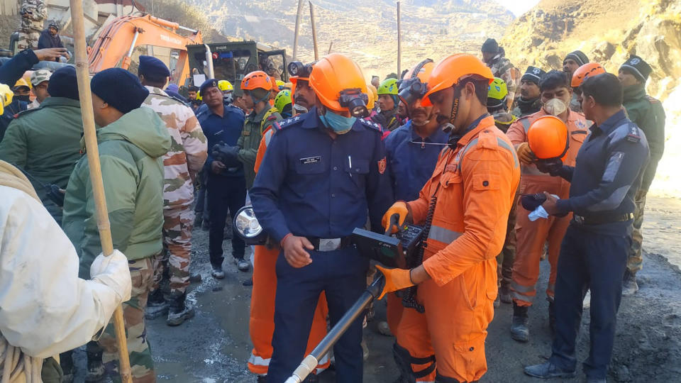 This photograph provided by National Disaster Response Force (NDRF) shows NDRF personnel search for more than three dozen power plant workers trapped in a tunnel after part of a Himalayan glacier broke off Sunday and sent a wall of water and debris rushing down the mountain in Tapovan area of the northern state of Uttarakhand, India, Monday, Feb.8, 2021. (National Disaster Response Force via AP)