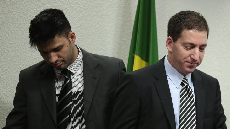 Glenn Greenwald (R), American journalist who first published the documents leaked by former NSA contractor Edward Snowden, reacts beside his partner David Miranda as he testifies in front of the Brazilian Federal Senate's Parliamentary Inquiry Committee, established to investigate allegations of spying by United States on Brazil, in Brasilia October 9, 2013. REUTERS/Ueslei Marcelino (BRAZIL - Tags: POLITICS MEDIA)