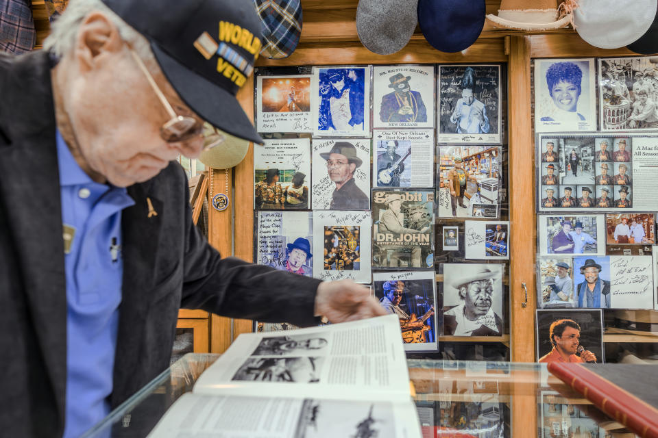 Seth Meyer looks at a World War II history book on the 370th Fighter Group, a group that he was part of, on Friday, Feb. 23, 2024 in New Orleans. Meyer was awarded the rank of chevalier, or knight, of the National Order of the Legion of Honor. (Chris Granger/The Times-Picayune/The New Orleans Advocate via AP)