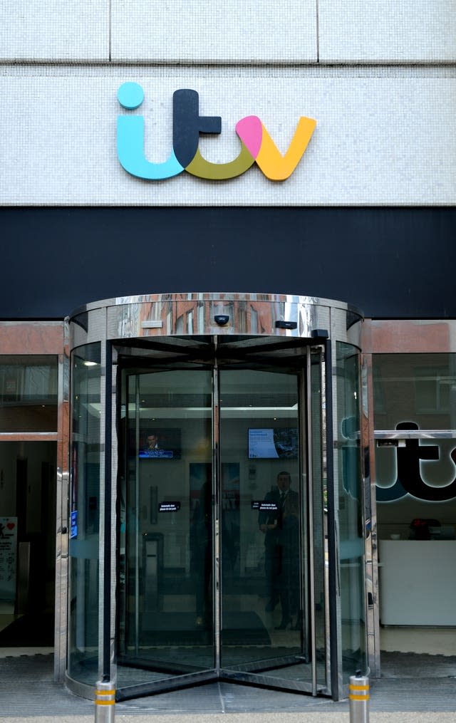 Revolving door to a glass-fronted building with a sign for ITV