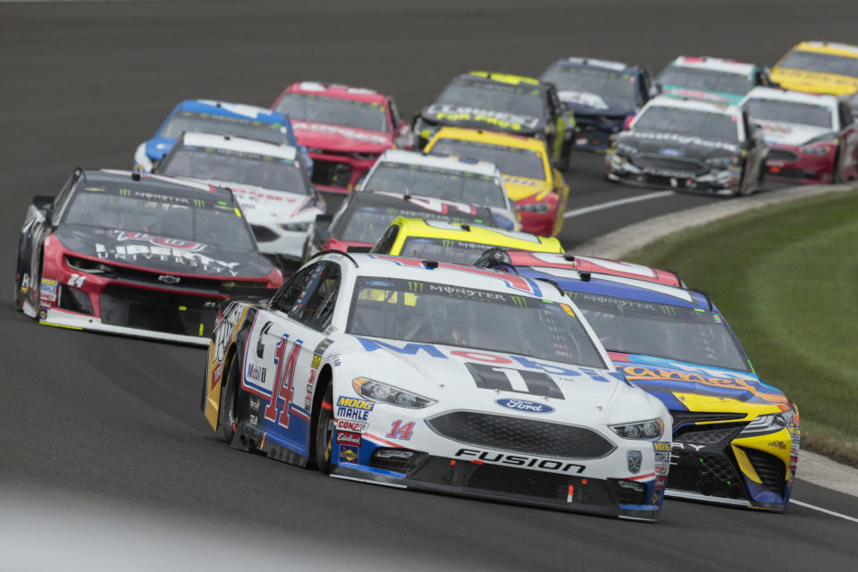 NASCAR Cup Series driver Clint Bowyer (14) leads a pack of cars through the first turn during the NASCAR Brickyard 400 auto race at Indianapolis Motor Speedway, in Indianapolis Monday, Sept. 10, 2018. (AP Photo/AJ Mast)