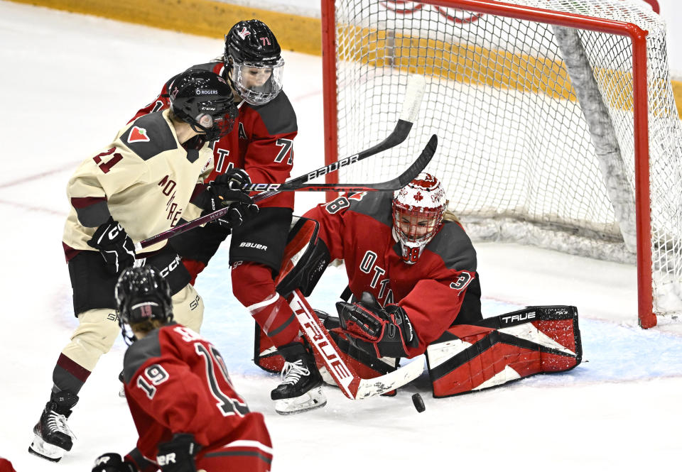Ottawa's Emerance Maschmeyer (38) makes a save in front Jincy Roese (71) and Montreal's Tereza Vanisova (21) during the third period of a PWHL hockey game Tuesday, Jan. 2, 2024, in Ottawa, Ontario. (Justin Tang/The Canadian Press via AP)
