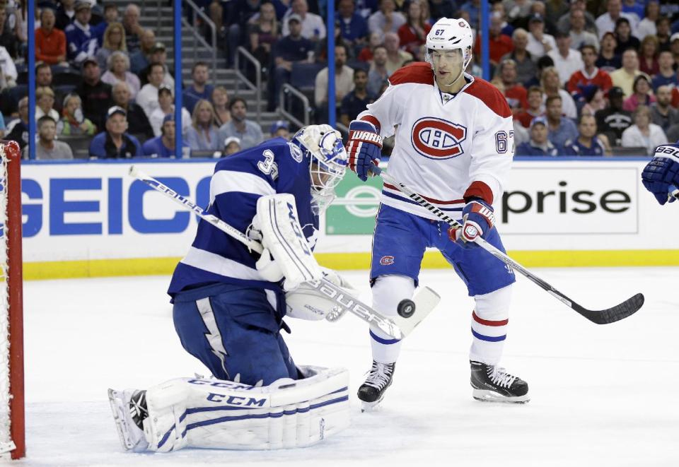 Tampa Bay Lightning goalie Anders Lindback (39), of Sweden, makes a stick-save as Montreal Canadiens left wing Max Pacioretty (67) looks for a rebound on a shot during the first period of Game 1 of a first-round NHL hockey playoff series on Wednesday, April 16, 2014, in Tampa, Fla. (AP Photo/Chris O'Meara)