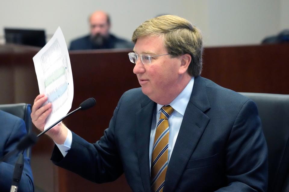 Mississippi Gov. Tate Reeves waves a sheet of revenue projections as he refuses to approve top lawmakers' proposed revenue estimates Wednesday, Nov. 15, 2023, during a meeting of the Joint Legislative Budget Committee, in Jackson, Miss. Reeves believes a lower projection than he wanted would make it more difficult to justify future income tax cuts.