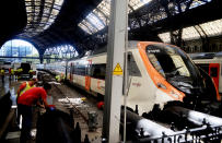 <p>Workers check a commuter train after it ran into the buffers on the platform of a train station in Barcelona, Spain, Friday July 28, 2017. (Photo: Adrian Quiroga/AP) </p>