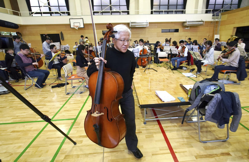 In this March 31, 2019, photo, Toshio Shiraishi, a longtime friend of Crown Prince Naruhito, holds his violoncello during a practice session of Shunyukai Symphony Orchestra in Tokyo. Shiraishi, a gray-haired banker who plays the cello, says the crown prince’s choice of instrument - viola - shows a lot about the kind of man he is. (AP Photo/Eugene Hoshiko)