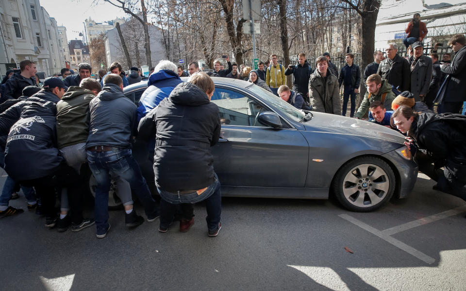 Opposition supporters move a car to block a van transporting detained anti-corruption campaigner and opposition figure Alexei Navalny during a rally in Moscow.