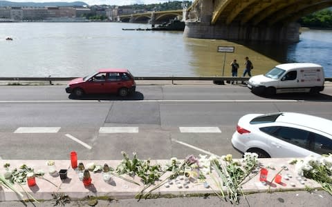 Flowers and candles are left in memory of the victims at the Margaret Bridge, the spot of the accident involving South Korean tourists, in Budapest - Credit: Noemi Bruzak/MTI