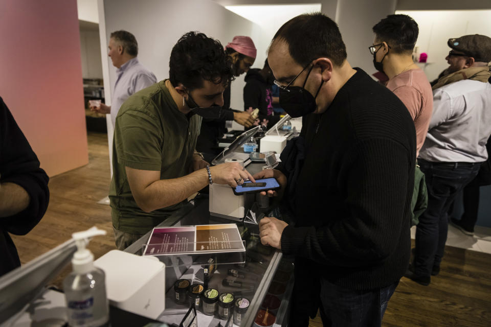 A person purchases cannabis products at Housing Works Cannabis Co., New York's first legal cannabis dispensary at 750 Broadway in Noho on Thursday, Dec. 29, 2022, in New York. (AP Photo/Stefan Jeremiah)