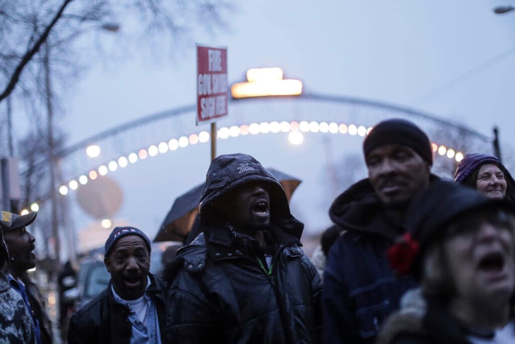 In a Friday Jan. 8, 2016, photo, Flint residents shout while protesting outside of Flint City Hall against Gov.Rick Snyder in Flint, Mich. (Ryan Garza/Detroit Free Press via AP)