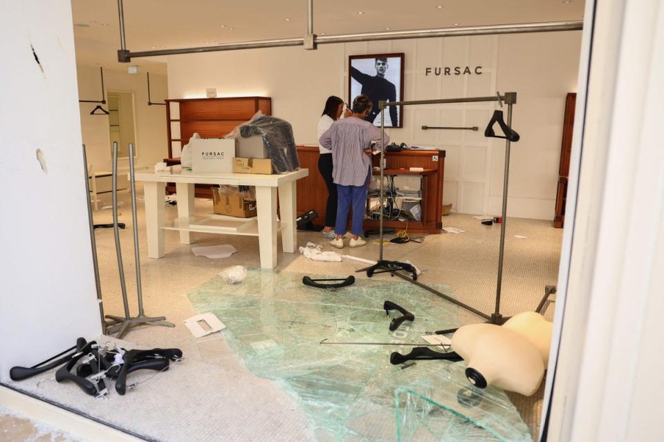 Employees examine a damaged Fursac shop in the centre of Marseille, southern France on Saturday (AFP via Getty Images)