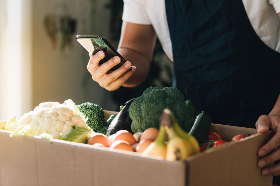 Cropped shot of man using smart phone to order vegetables and fruits delivery online