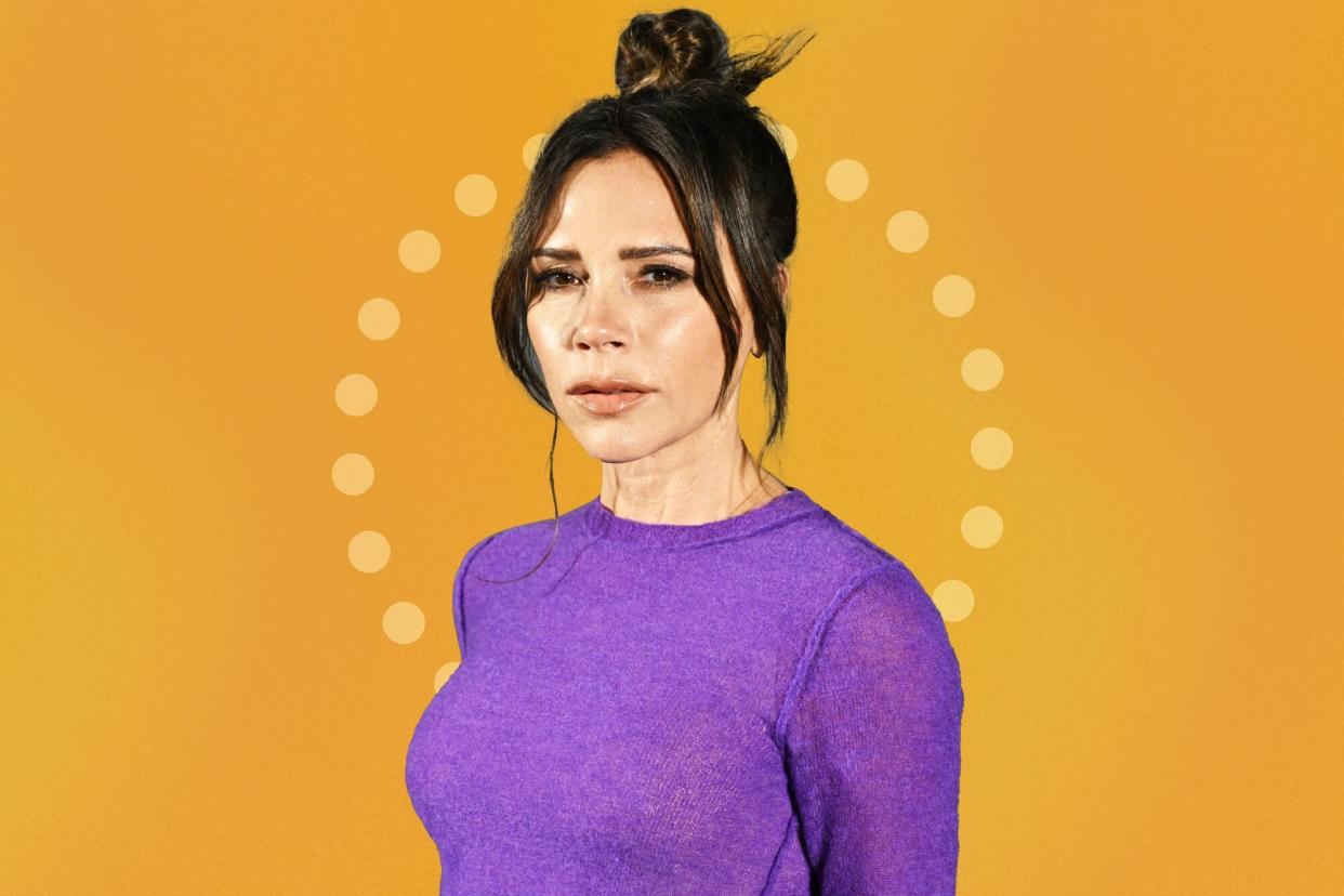 Close up of Victoria Beckham wearing a purple long sleeve against an orange background